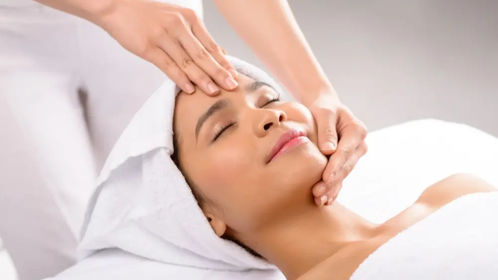 Technician performing facial massage to relax facial muscles and stimulate skin circulation